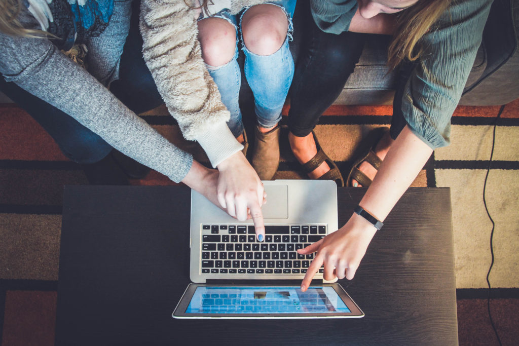 Three women working on a laptop