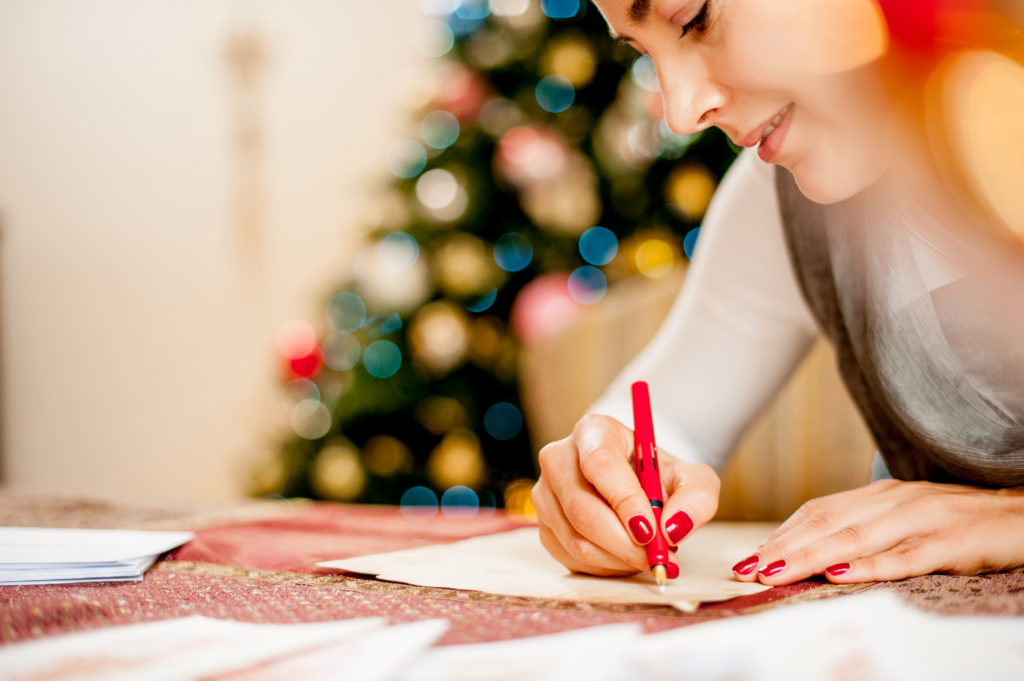 Woman Writing a Christmas Card on Table