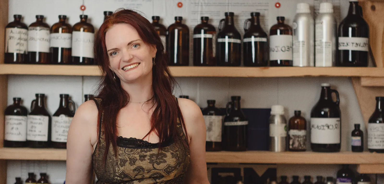 Woman stands in front of bottles and tinctures